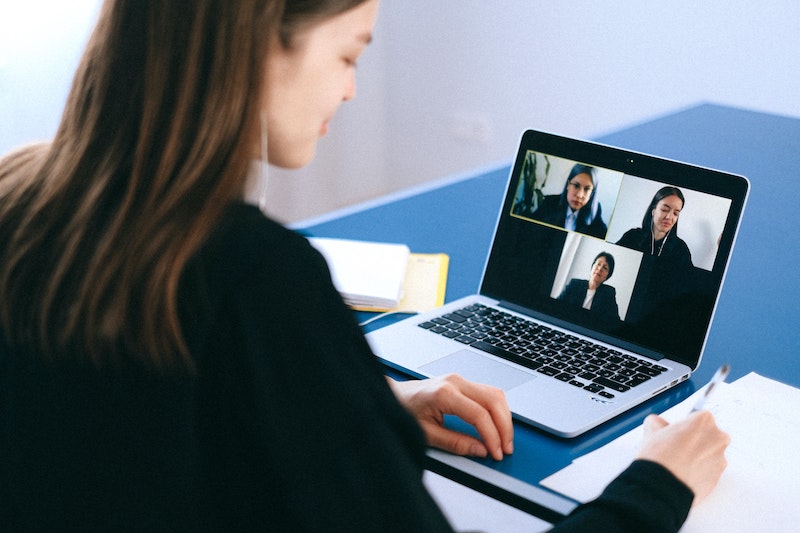 Professional woman using videoconferencing tips while on a three-way call.